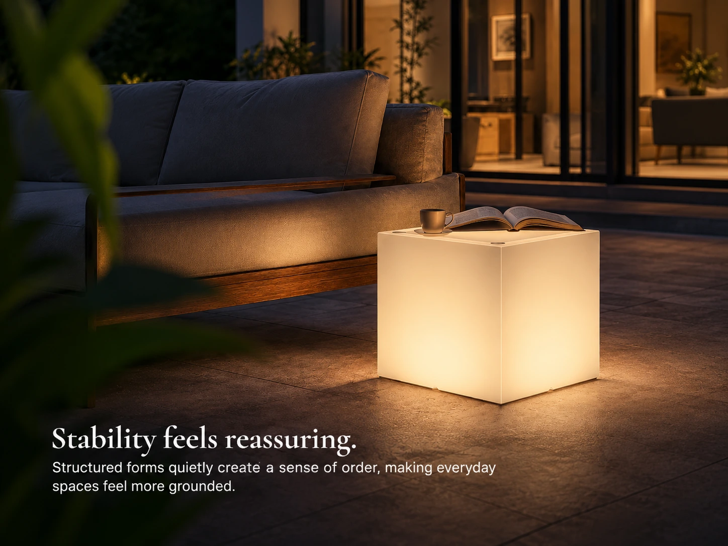 LED Cubic menyala di samping sofa outdoor, dengan cangkir dan buku di atasnya